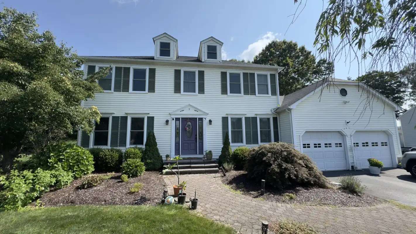 White two-story house with a garage and manicured landscaping